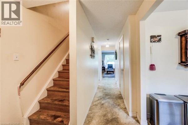 Interior hallway with wooden stairs on the left and doors leading to rooms. - 428b Dunvegan Drive, Waterloo