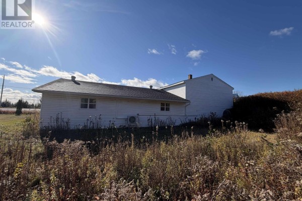 Rear view of the house with garden area and clear sky - 429 Highway 7, Ecum Secum