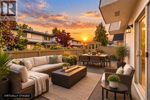 Staged patio area with outdoor furniture, fire pit, and dining set during sunset. - 43 4061 Larchwood Dr, Saanich