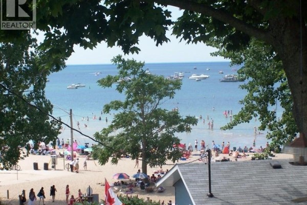 View of the lake with a flagpole and Canadian flags near the waterfront. - 43 Bucks Park, Port Dover