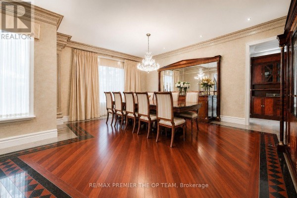 Formal dining room with a large table and chairs, crystal chandelier, and a mirrored wall. - 43 Cowan Drive, Vaughan