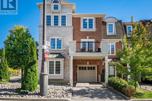 Front view of a townhouse with a covered garage and balcony. - 43 Deans Drive, Toronto