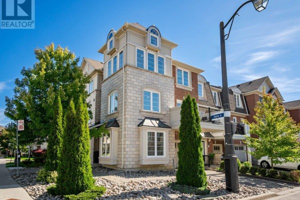 Townhouse exterior with multi-level windows and a stone base. - 43 Deans Drive, Toronto