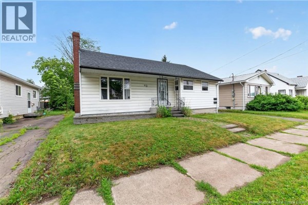 Angle view of the bungalow's front entrance, walkway, and grassy front yard. - 43 Derby Street, Moncton
