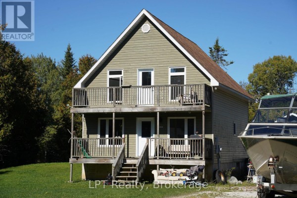 Two-story house with green siding, upper and lower decks, and stairs leading to front door. - 43 Henwood Street, Northern Bruce Peninsula