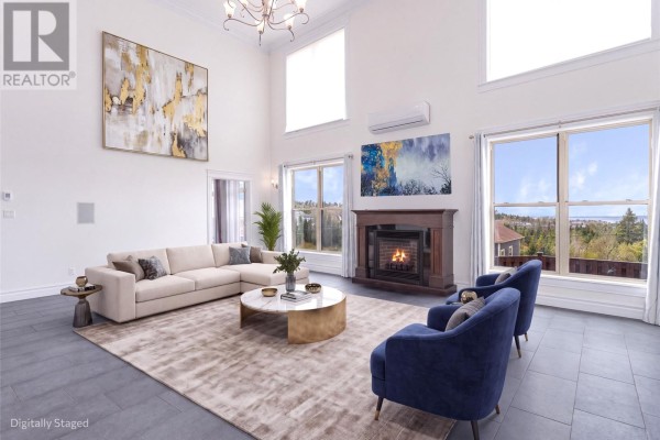 Living room with a large sectional sofa, fireplace, television, and windows overlooking the water. - 43 Kirkston Avenue, Conception Bay South