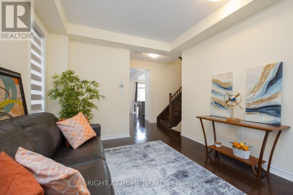 Living room showing sofa, rug, console table, and view into kitchen area. - 43 Vickery Street, Whitby