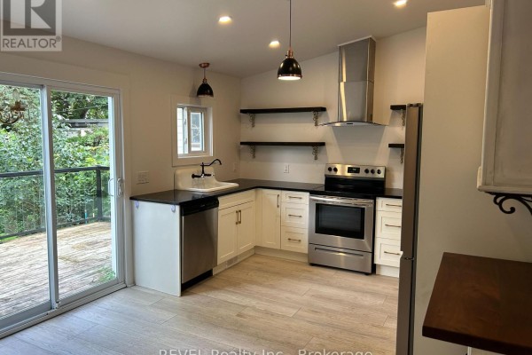 Kitchen with white cabinets, stainless steel appliances, and a view of a wooden deck. - 43 Wiley Street, St  Catharines