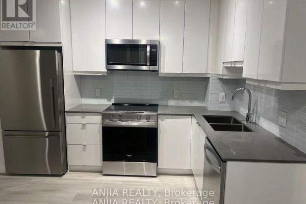 Modern kitchen with stainless steel appliances, white cabinetry, and grey countertops. - 430 - 3270 Sheppard Avenue E, Toronto