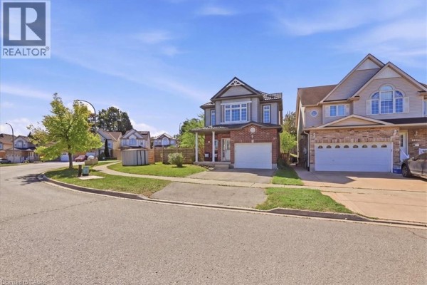 Street view of the house with neighboring properties on a clear day. - 430 Mountain Laurel Crescent, Kitchener