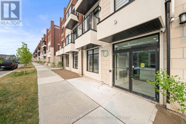 Exterior view of the commercial building facade with multiple units and a sidewalk. - 431 Dougall Avenue, Caledon