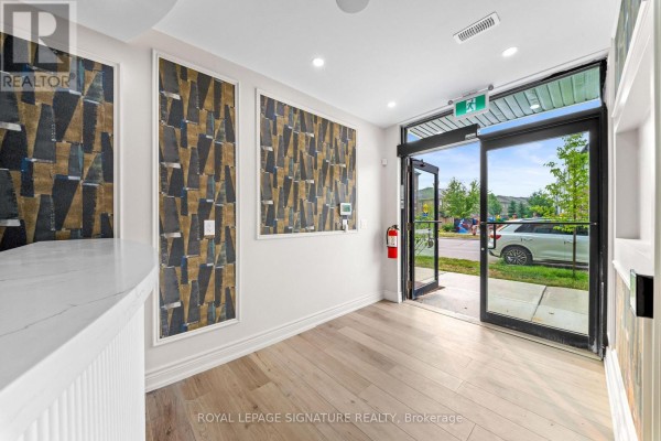Lobby with glass doors leading outside, a reception desk, and a fire extinguisher. - 431 Dougall Avenue, Caledon