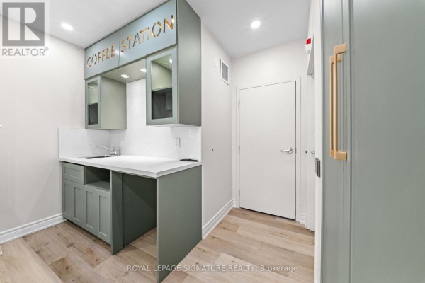 Small kitchenette area with green cabinetry, a sink, and a sign reading "COFFEE STATION". - 431 Dougall Avenue, Caledon