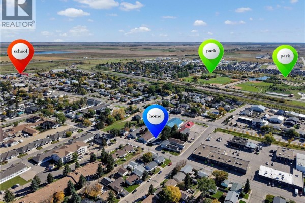 Aerial view of Warman, Saskatchewan, showing the property location labeled 'home' near schools and parks. - 431 Peters Street, Warman