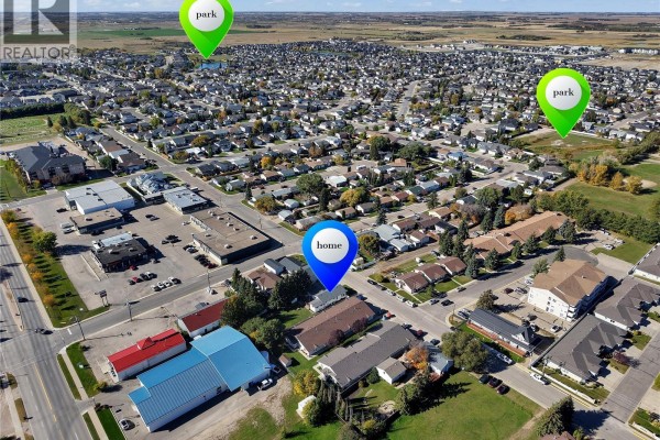 Aerial view of Warman, Saskatchewan, showing the property location labeled 'home' surrounded by residential homes and commercial buildings. - 431 Peters Street, Warman