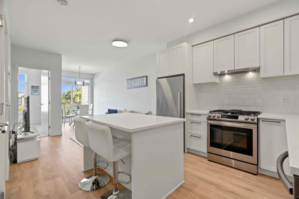 Kitchen with white cabinets, stainless steel appliances, and a large island with stools. - 432 5415 Brydon Crescent, Langley