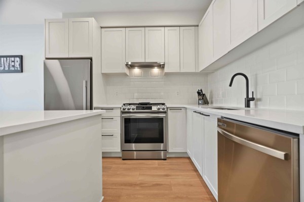 Close-up of the kitchen with white subway tile backsplash, stainless steel appliances, and black faucet. - 432 5415 Brydon Crescent, Langley