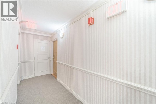 Interior view of a stacked washer and dryer unit in a closet near the apartment entrance. - 432 Main Street E Unit# 601, Hamilton