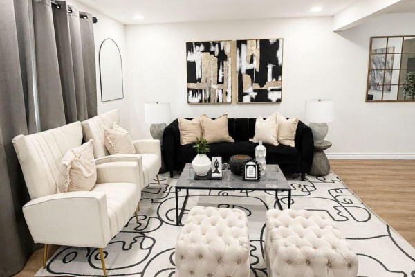 Two cream armchairs and a black sofa in a living room with a modern rug. - 433a Dunvegan Drive, Waterloo