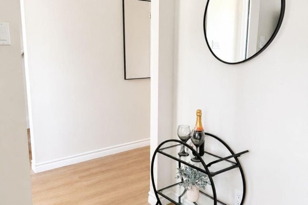 Black metal bar cart with champagne bottle and glasses against a white wall. - 433a Dunvegan Drive, Waterloo