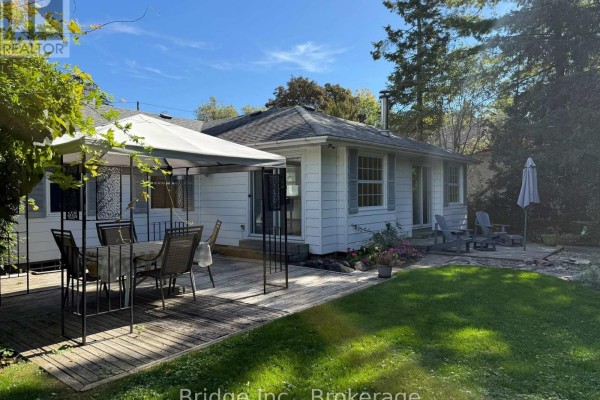 Backyard view showing a wooden deck with outdoor furniture and a white gazebo. - 434 Apple Lane, Mississauga