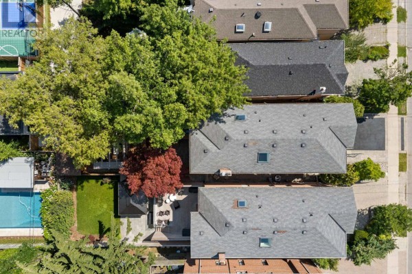 Hallway with light wood floors, white walls, glass railings, and a skylight overhead. - 434 Bedford Park Avenue, Toronto