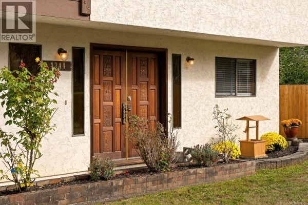 Close-up of the textured double front doors with decorative panels and landscaping. - 4344 Briardale Rd, Royston
