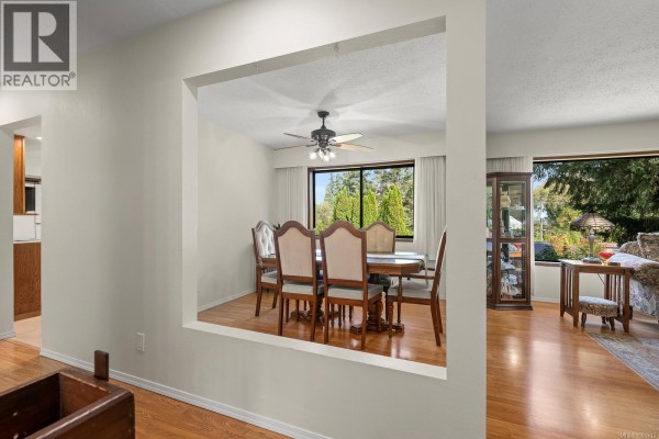 View through an opening into a dining room with a wooden table and chairs. - 4344 Briardale Rd, Royston