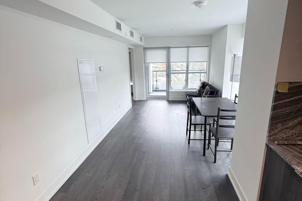 Open concept living and dining area with a balcony and dark wood floors. - 435 - 5 Mabelle Avenue, Toronto