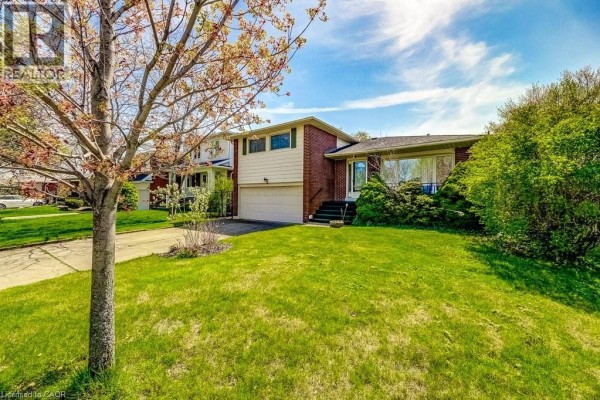 Canadian house exterior with well-kept lawn and mature trees in residential neighborhood. - 4356 Dublin Crescent, Burlington
