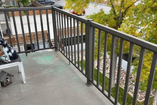 Balcony view of a pathway, grass, trees, and building exterior. - 436, 1237 4 Avenue S, Lethbridge
