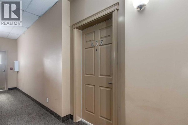 Hallway with carpet flooring and a closed door labeled 436. - 436, 1727 54 Street Se, Calgary