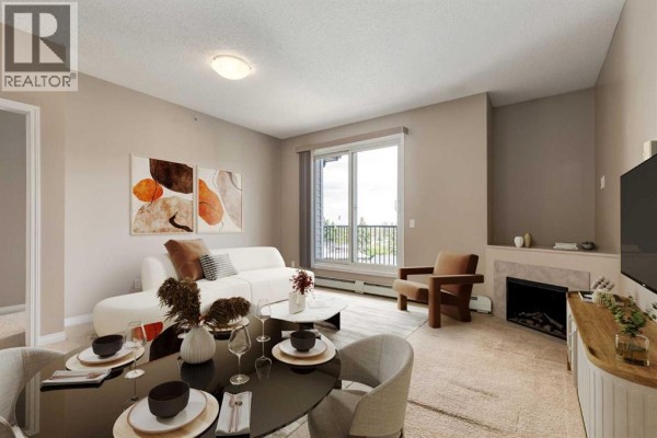 Living room with a white sectional sofa, armchair, fireplace, and a sliding glass door to a balcony. - 436, 1727 54 Street Se, Calgary