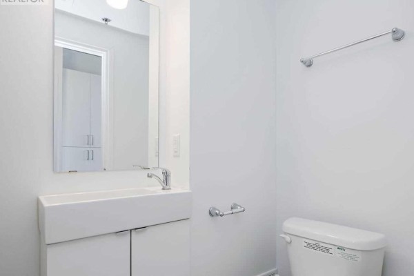 Close-up of the studio apartment kitchenette with granite countertops, sink, and mirrored backsplash. - 436 - 1900 Simcoe Street N, Oshawa