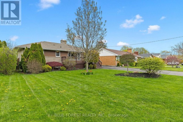 Front exterior of a single-family home with address 436, a wooden deck, and manicured landscaping. - 436 Baseline Road E, London South
