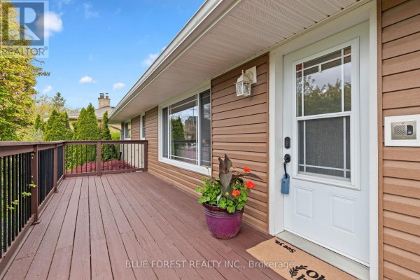 Driveway and front exterior of a single-family home with brown siding and brick on a clear day. - 436 Baseline Road E, London South