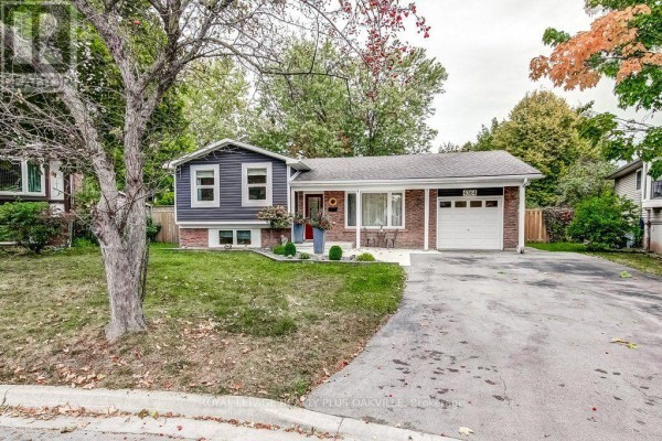 Side view of the house showing the attached single garage, brick exterior, and covered walkway to the front door. - 4364 Ayr Place, Burlington