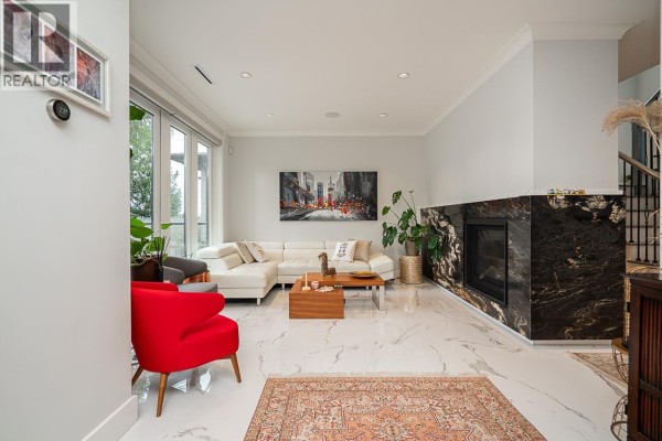Living room with a sectional sofa, fireplace, and marble flooring. - 4365 Mountain Highway, North Vancouver