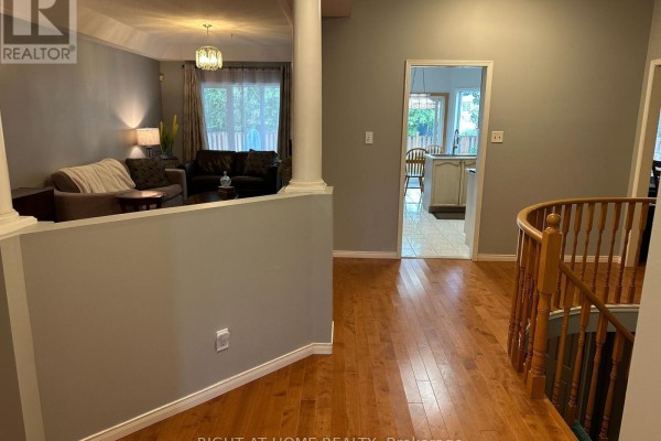 Interior view of a home hallway with hardwood floors and a staircase railing. - 4369 Goldenwood Drive, Windsor