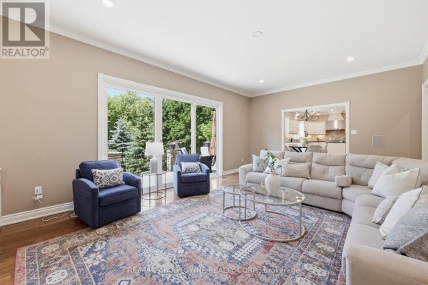 Living room with sectional sofa, armchairs, glass coffee table, and ornate rug - 437 Cairncroft Road Oakville