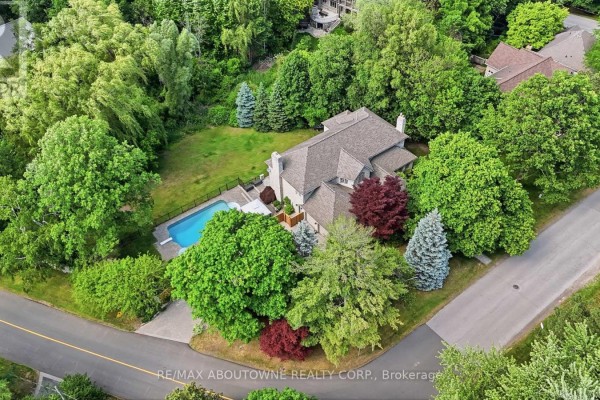 Aerial view of a large house with a swimming pool surrounded by mature trees. - 437 Cairncroft Road, Oakville