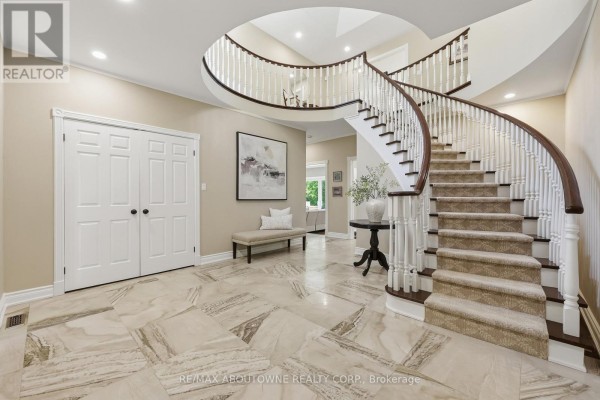 Curved staircase, bench seating, and large floor tiles in a grand foyer - 437 Cairncroft Road Oakville