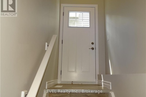 Close-up of the front door with address number 438, wooden pillar, and stone accents. - 438 Mcalpine Avenue N, Welland