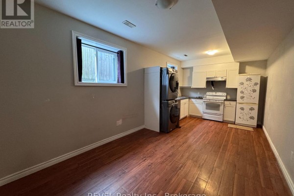 Open-concept living and dining area with a dark leather sectional sofa and dining table. - 438 Mcalpine Avenue N, Welland
