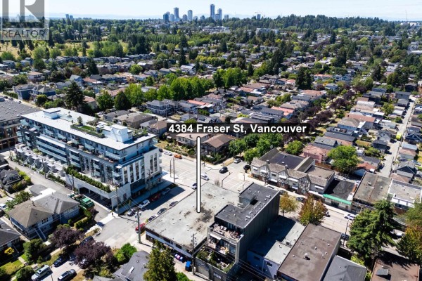 Aerial view of 4384 Fraser Street Vancouver building at dusk with city skyline - 4384 Fraser Street, Vancouver