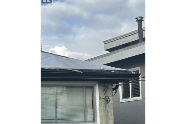 Roof view showing a flat surface with drainage and nearby structures. - 4386 Oxford Street, Burnaby