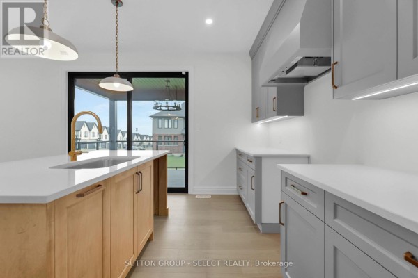 Kitchen island with sink and gold faucet, grey and wood cabinets - 4387 Green Bend Road London South