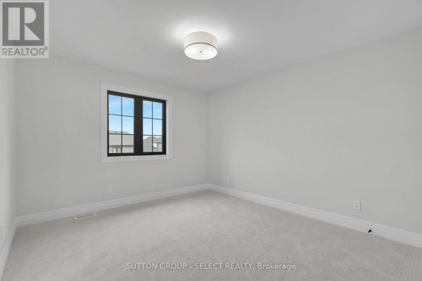 Modern bedroom with black-framed window and neutral carpet - 4387 Green Bend Road London South