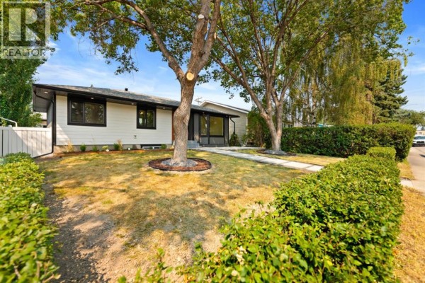Side view of the renovated bungalow with manicured hedges and lawn. - 439 Arlington Drive Se, Calgary
