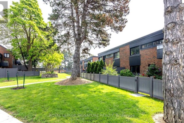 Exterior view of brick townhouses with dark trim and grey fences. - 44 - 51 Broadfield Drive, Toronto